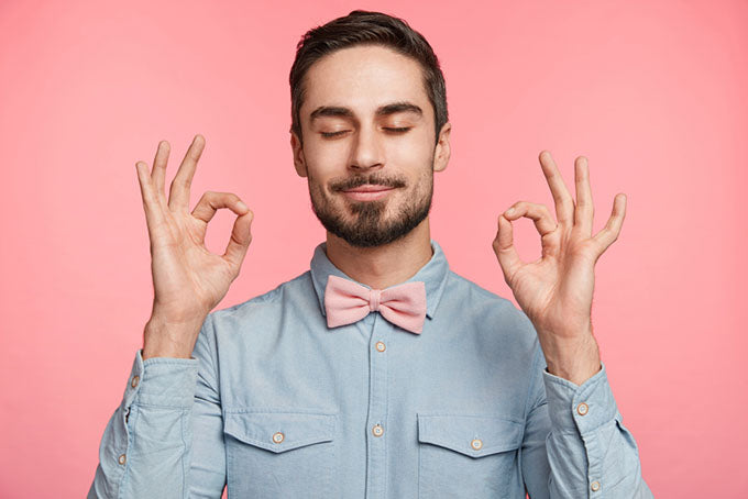 a calm bearded man making ok signs