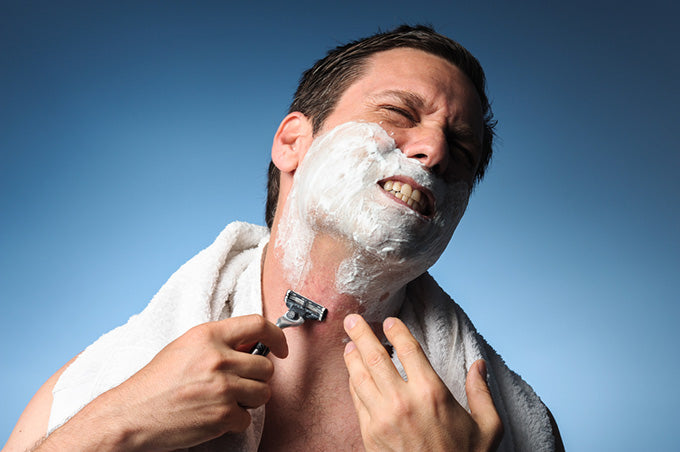 man gritting teeth shaving razor burn