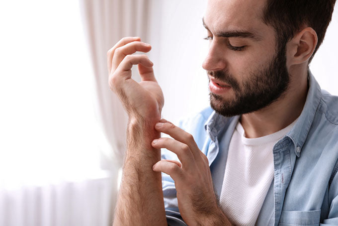 man scratching wrist