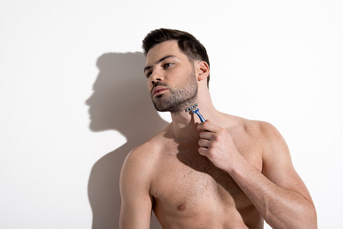 man shaving shirtless