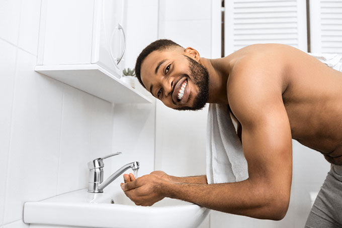 man smiles over bathroom sink