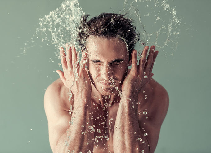 man splashing water onto face