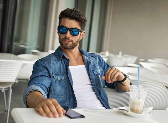 a man with sunglasses sitting at a patio dining table