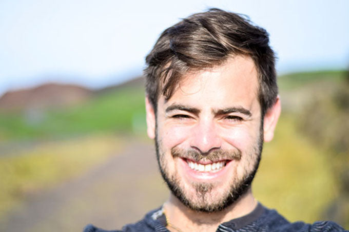 a man outside smiling on a sunny day