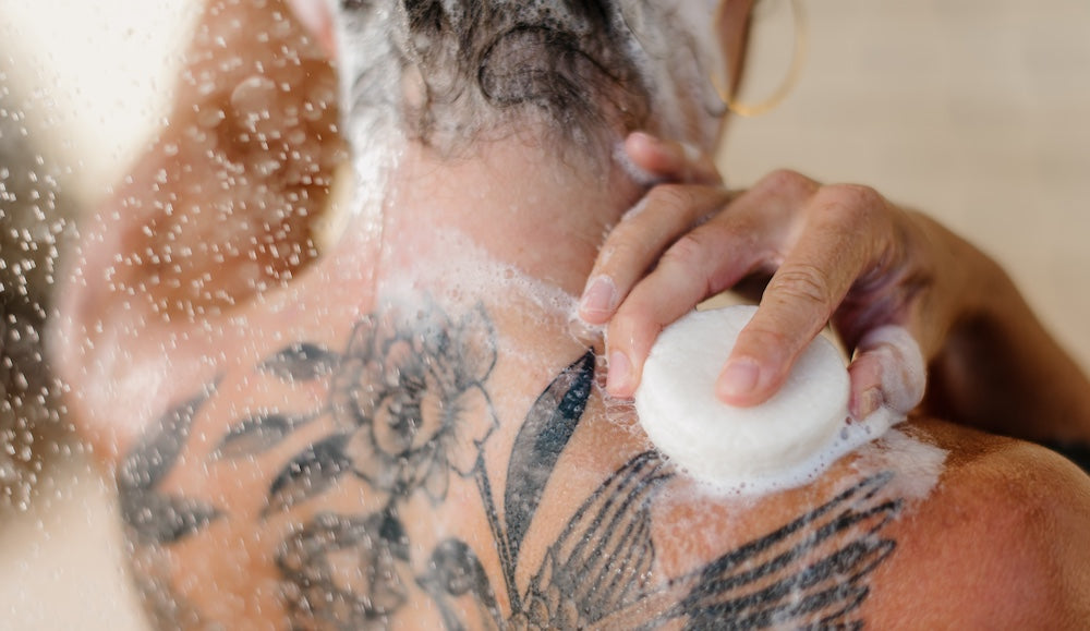 A woman using a shampoo bar with natural ingredients to wash her hair and body