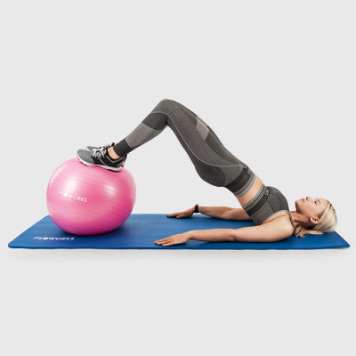 Girl Exercising on a Proworks Yoga Mat with a Proworks Exercise Ball