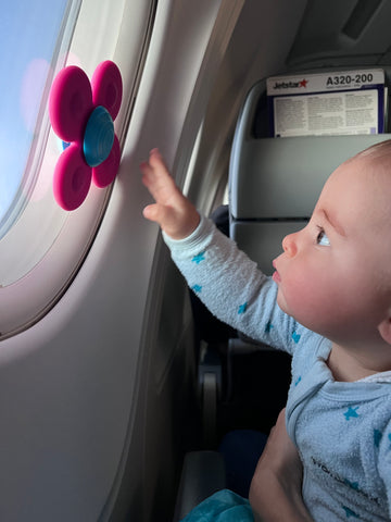 Baby playing with Whirly Squigz on plane