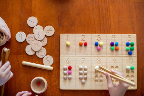 Child practicing one-to-one correspondence with a montessori counting board.