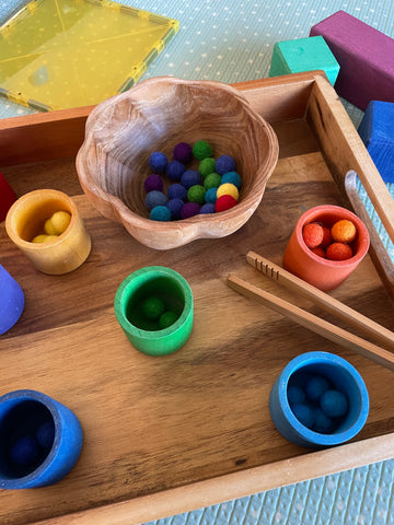 Colour matching activity with pom-poms and Grimm's cups.