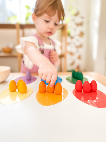 Little girl sorting colour egg Grapat mandalas