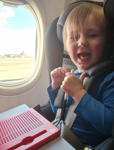 Toddler playing with Magnatab on plane.