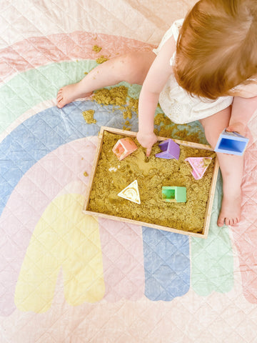 Toddler playing with calming sand and triblox