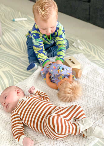 Toddler changing a baby doll's nappy.