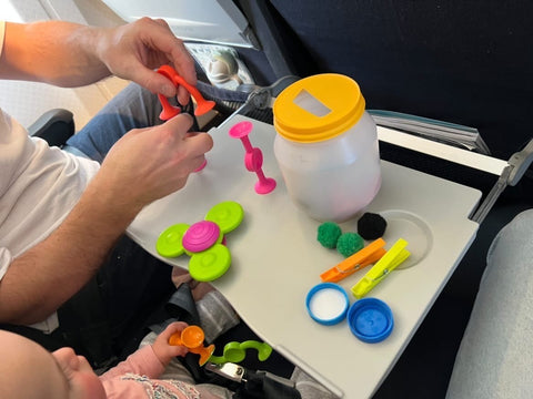 Toddler playing on a plane with Squigz, Whirly Squigz and doing posting