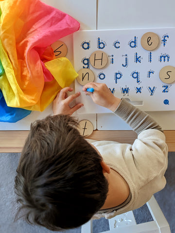 Young child matching wooden letters and magnatab