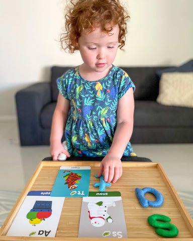 Young girl playing with felt letters and alphabet flashcards