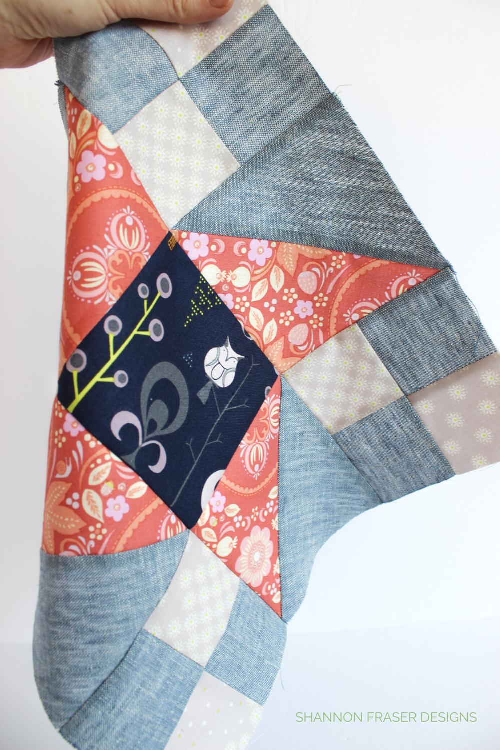Close-up of the Irish Vortex quilt block in coral, cream, navy and chambray linen | Irish Vortex quilt pattern | Shannon Fraser Designs #quiltblock