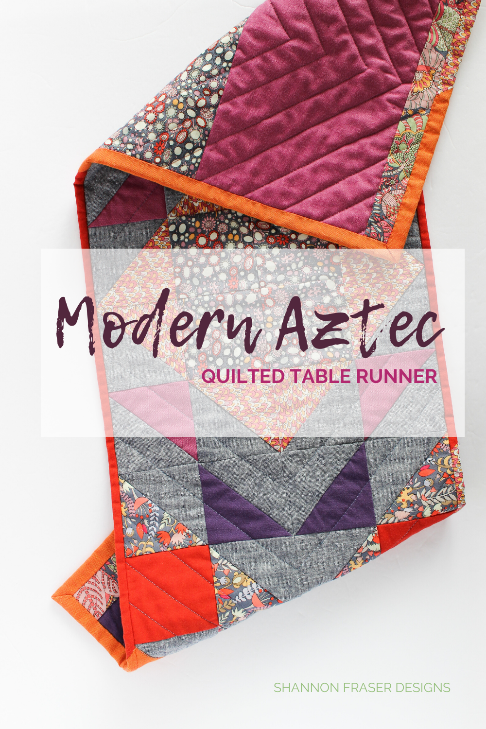 Modern Aztec quilted table runner folded on the table - red, orange, purple, navy and floral table runner | Fall home decor | Shannon Fraser Designs #tablerunner