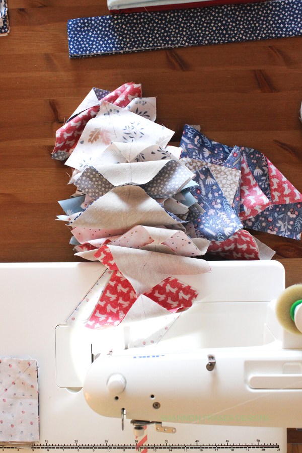 Stack of half square triangles being chain pieced on the sewing machine | Quilt Tutorial: Chain Piecing | Shannon Fraser Designs