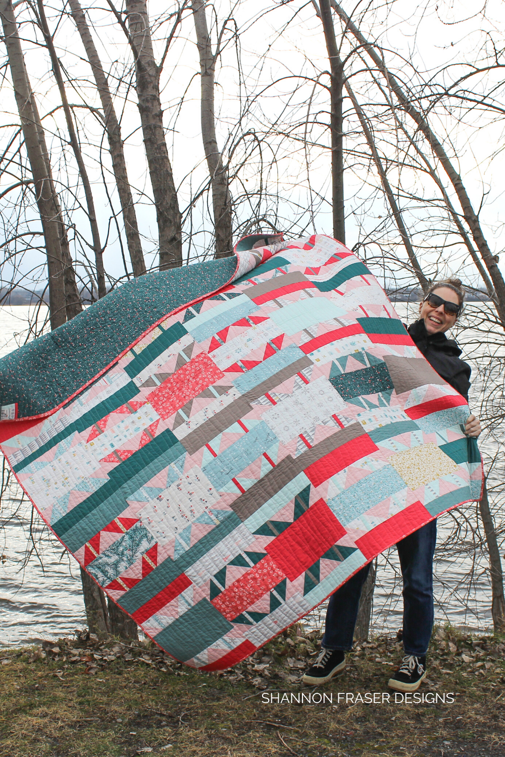 Shannon holding her completed Shattered Star holiday quilt from the Shattered Star Quilt Along | Shannon Fraser Designs #modernquilter