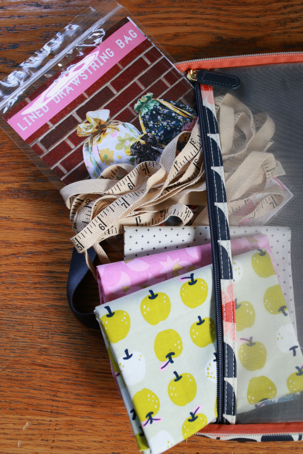 Pattern and fat quarters being tucked inside Jeni's travel sewing bag | What's in Your Sewing Bag In Color Order? | Shannon Fraser Designs' series #sewingpattern