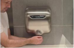 A Man Drying Hands Under XLERATOR Hand Dryer