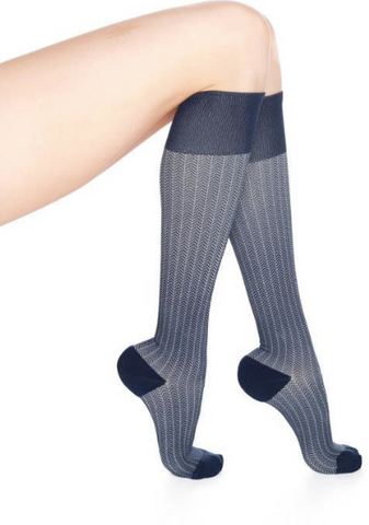 bent legs wearing herringbone patterned, navy and gray knee high socks