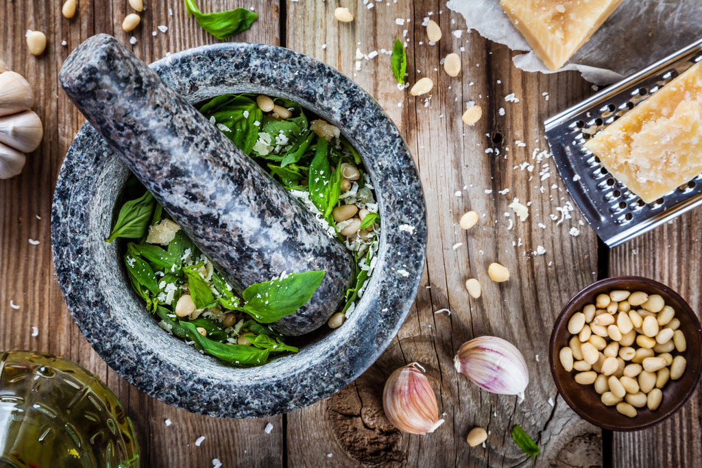 mortar and pestle loaded with basil