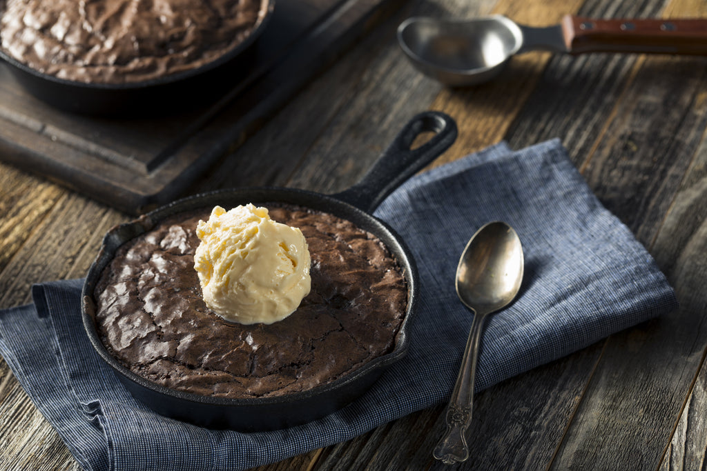 brownie in a cast iron skillet topped with ice cream