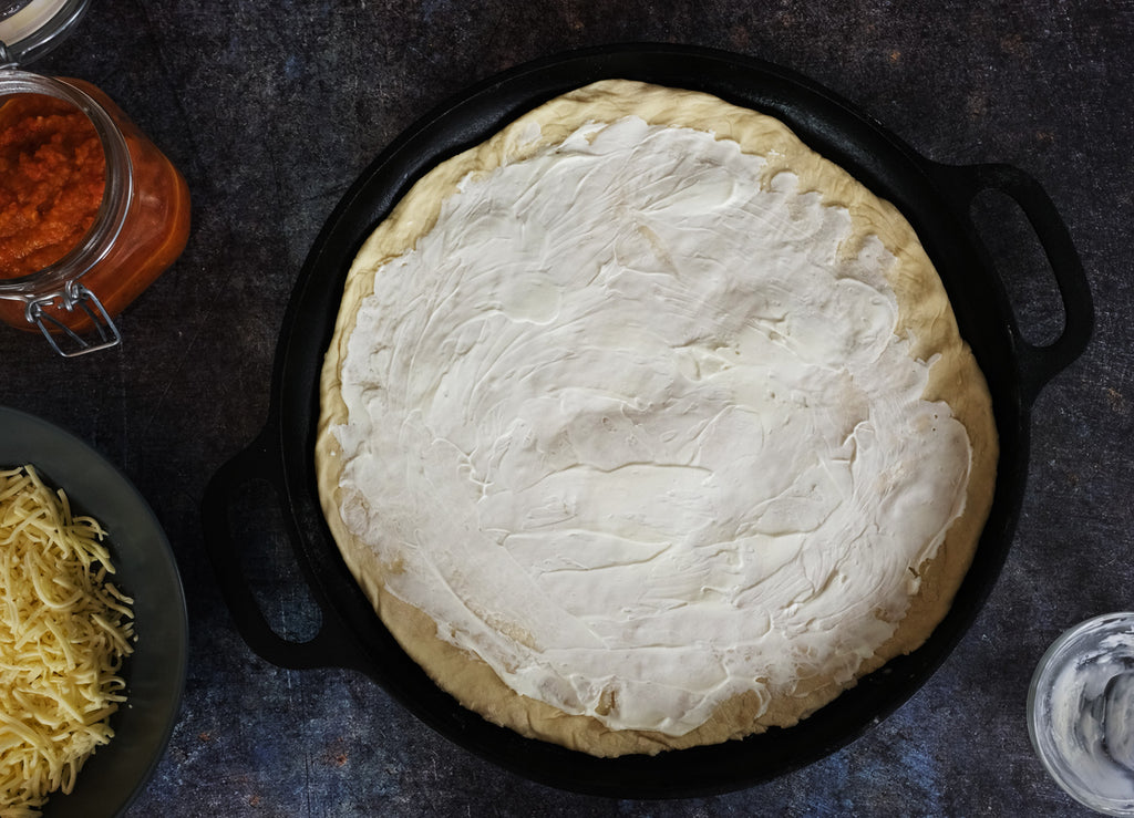 crème fraiche spread on the pizza dough