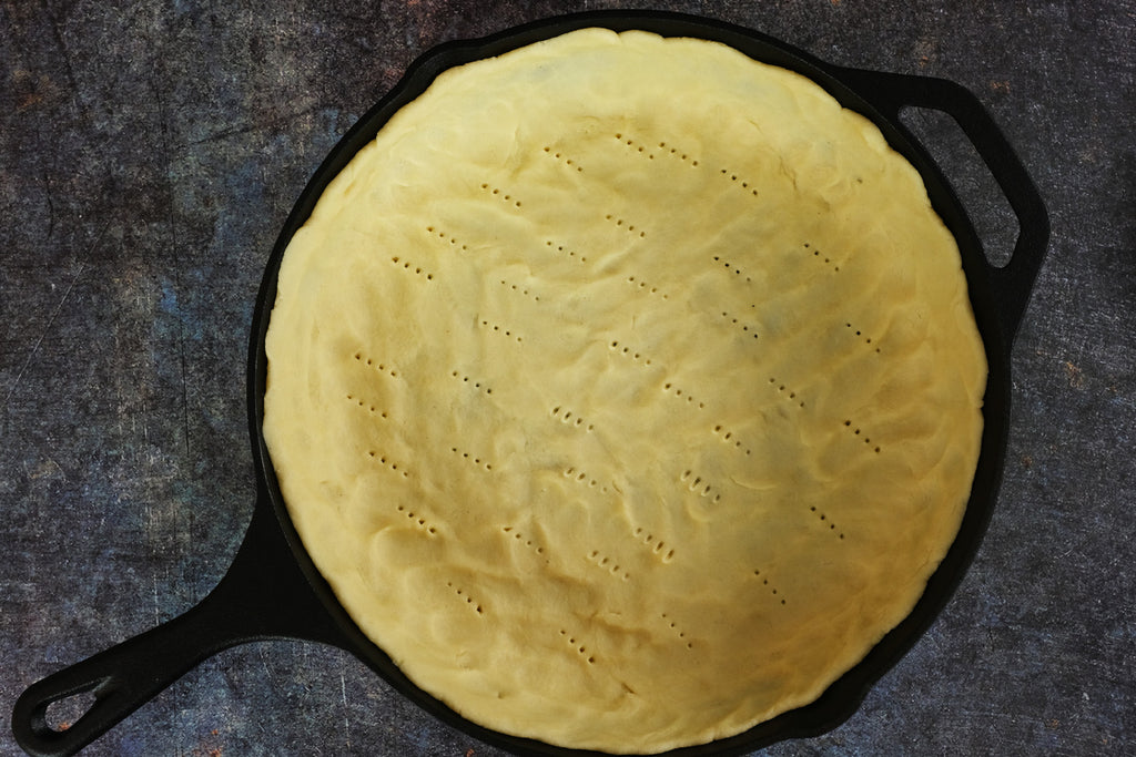 pie dough pressed out in a 12 inch cast iron skillet