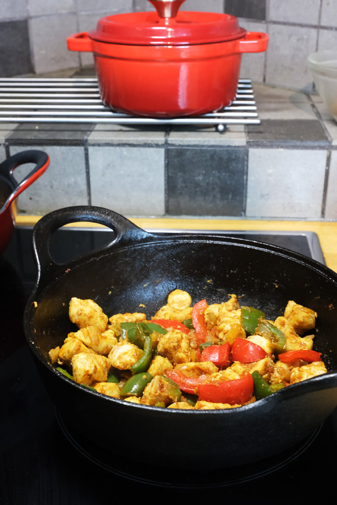 cast iron balti dish on the stove cooking balti curry chicken