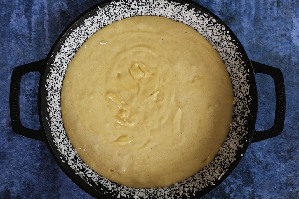 cake batter in a cast iron skillet with loop handles