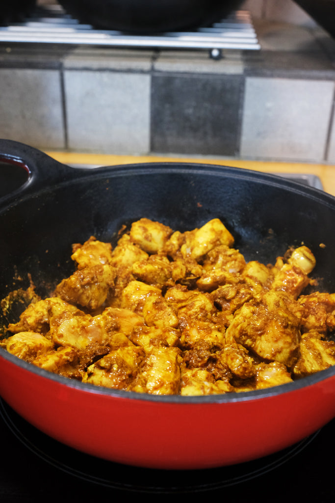 browning chicken in an enameled cast iron balti dish