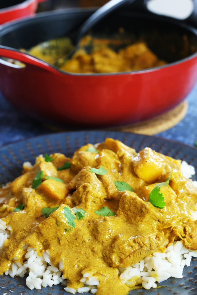 mango chicken balti served with enameled cast iron balti dish casserole in the background