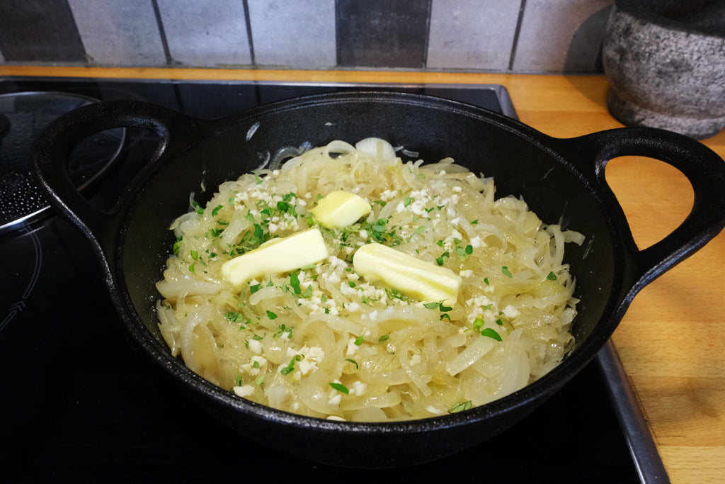 onions with garlic thyme and butter in a cast iron balti dish casserole
