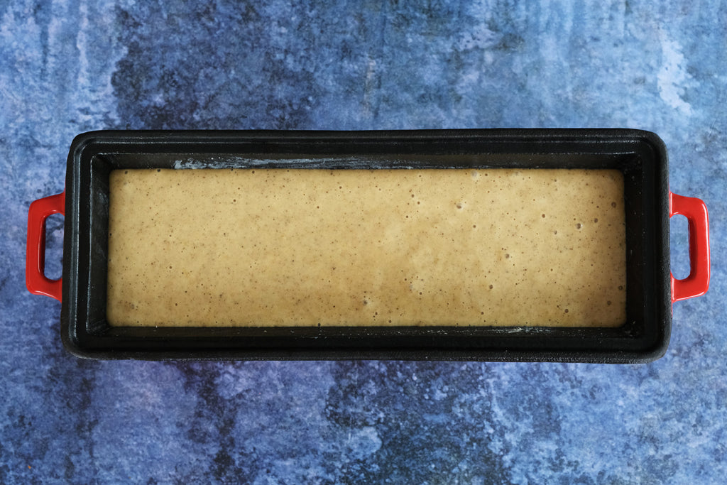 spice cake batter in an enameled cast iron bread pan