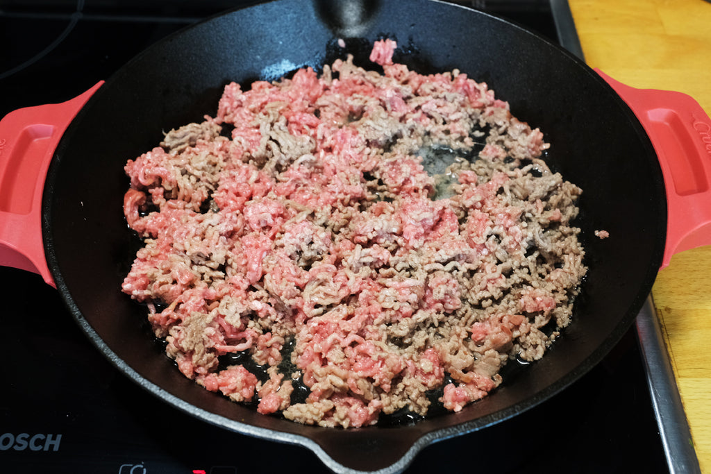 ground beef brownded in a crucible cookware 12" cast iron skillet with loop handles