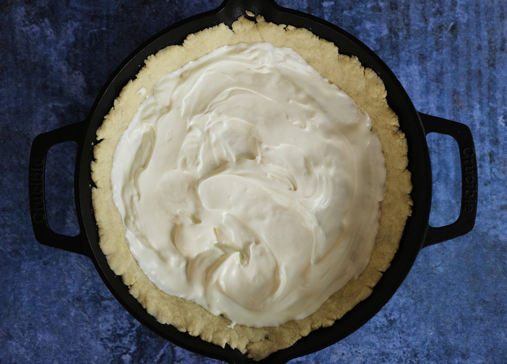 crame fraiche added to the pie crust in a 10.25" cast iron skillet