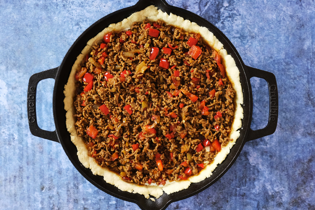 taco filling added to the crust of the taco pie in a Crucible Cookware 10.25" cast iron skillet with loop handles