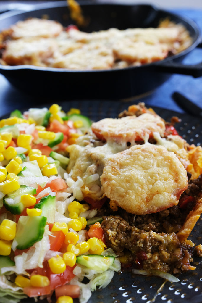 taco pie served with a salad and a 10.25" inch cast iron skillet in the back ground