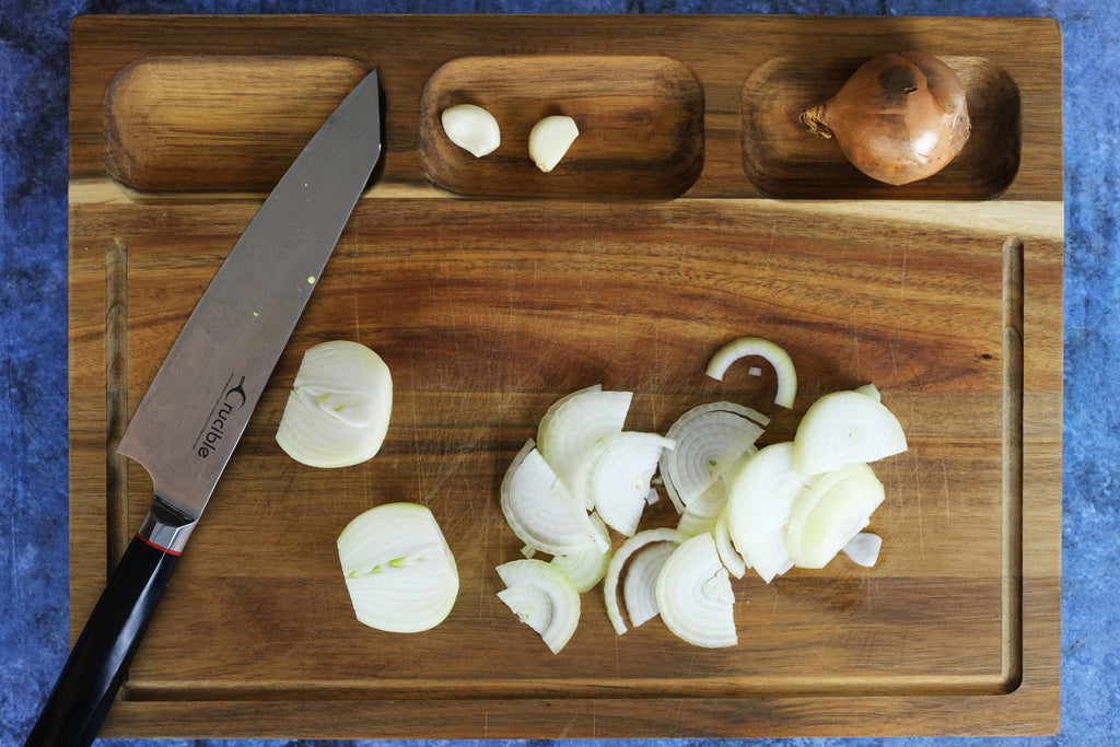 sliced onino on a wooden cutting board with sorting compartments