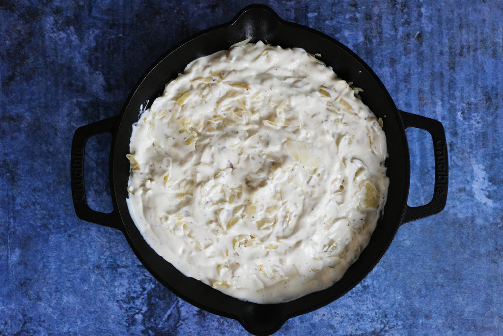 cabbage with added cream and cream cheese in a cast iron skillet with loop handles