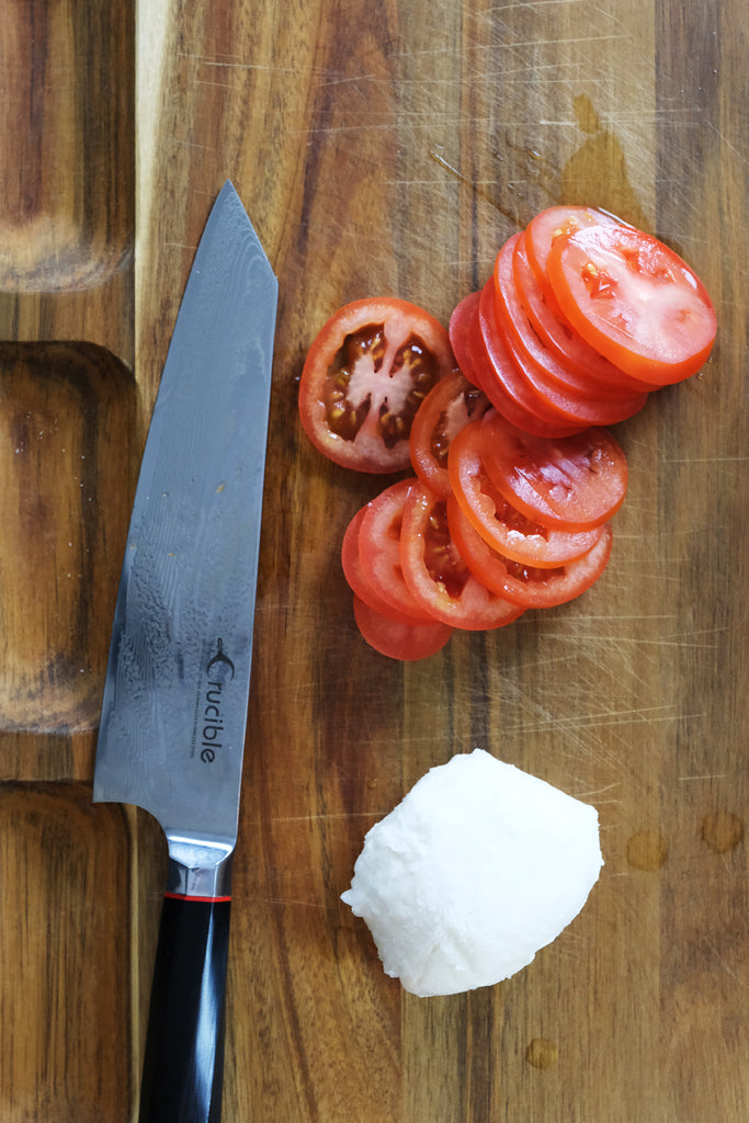 tomatoes and mozzarella on a wooden cutting board