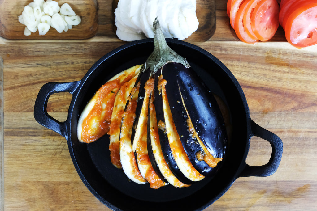 eggplant hasselback in a cast iron serving pan skillet