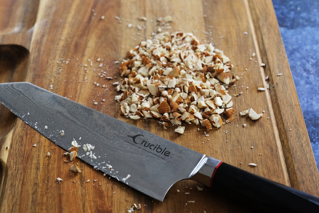 grossly chopped almonds on a wooden cutting board