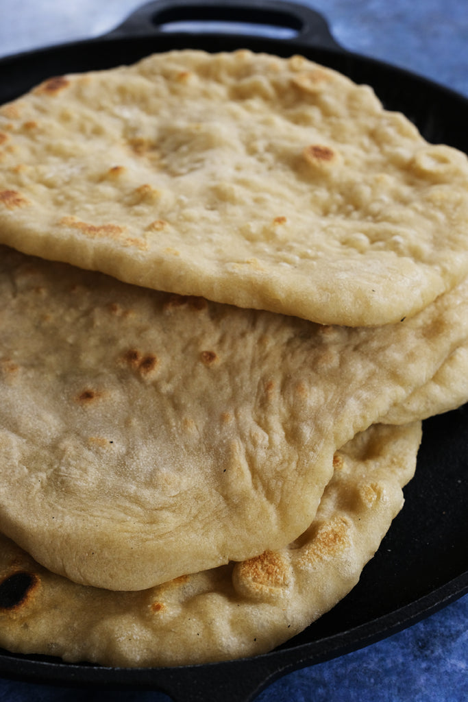 gyro pita breads on a cast iron pizza and baking pan