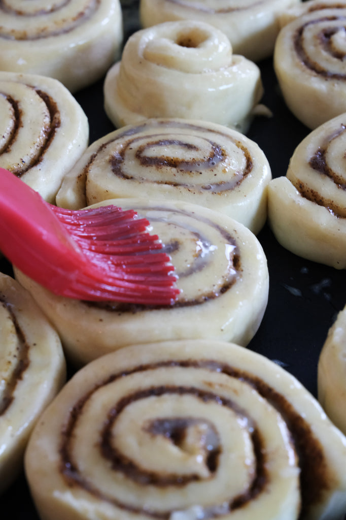 brushing the cinnamon rolls with egg wash