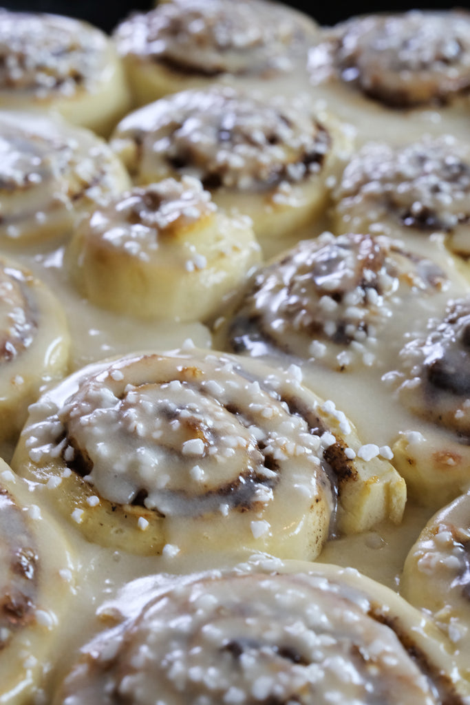 cinnamon rolls topped with pearl sugar and icing glaze
