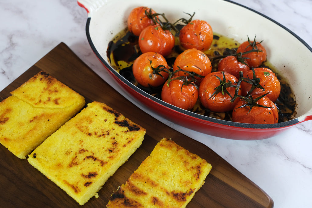 Polenta on a serving board with roasted tomatoes